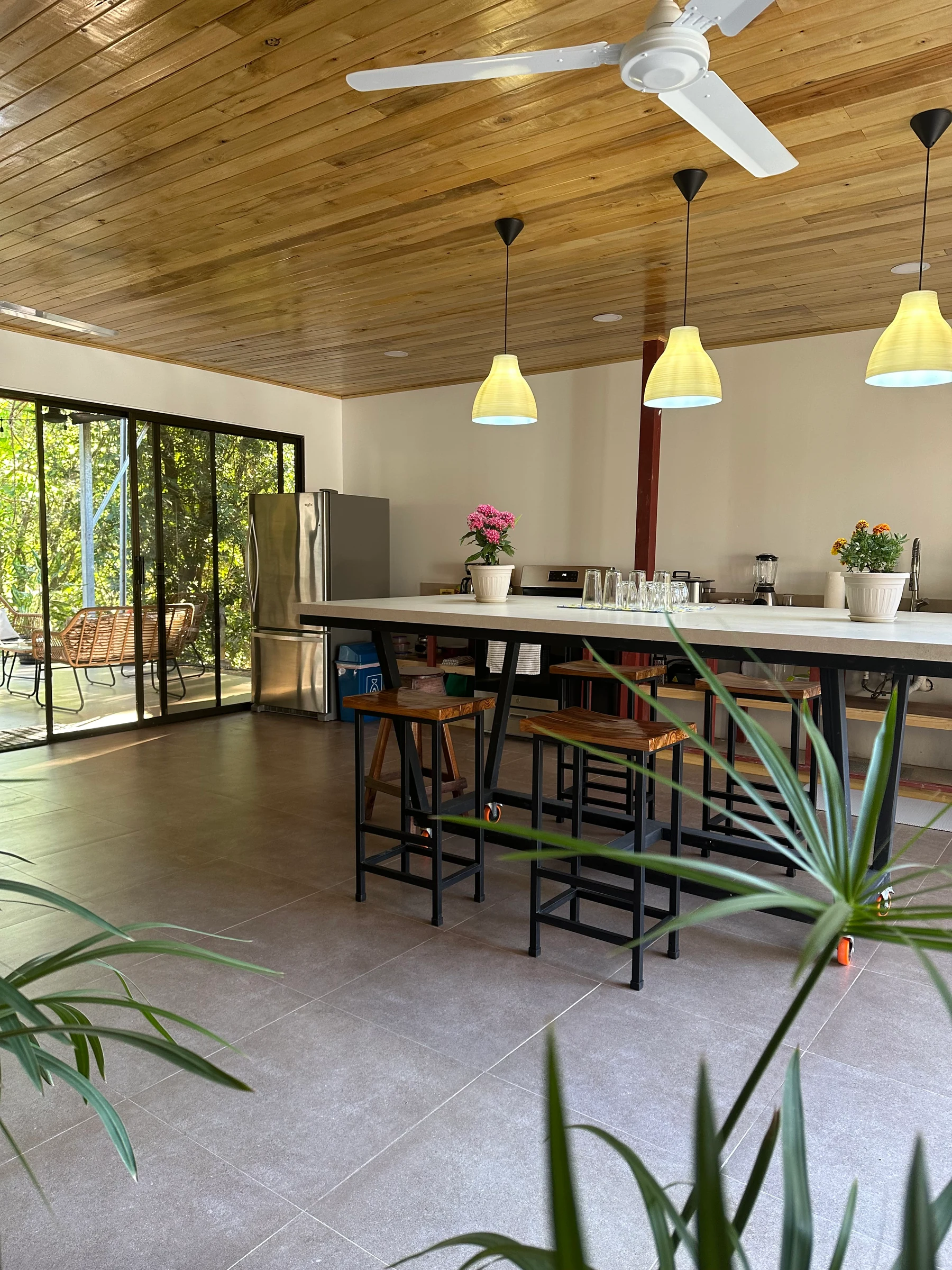 The shared kitchen and gathering space at the NSI student residence, with a breakfast counter and garden-facing windows.